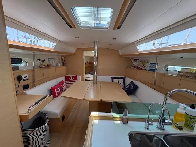 Slide: The Image of Interior of 2018 Jeanneau Sun Odyssey 389 sailboat with modern kitchen and cozy seating area. - 12