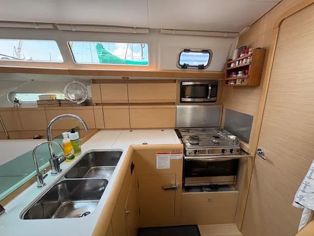 Slide: The Image of Modern kitchen in 2018 Jeanneau Sun Odyssey 389 yacht with stove, sink, and microwave. - 14