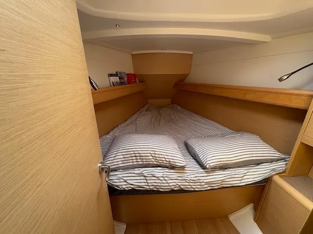 Slide: The Image of Cozy cabin interior of 2018 Jeanneau Sun Odyssey 389 sailboat with striped bedding. - 16