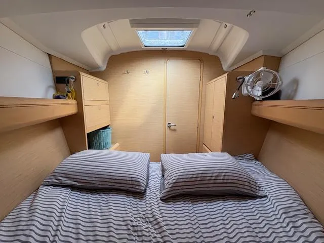 Slide: The Image of Cozy cabin interior of 2018 Jeanneau Sun Odyssey 389 sailboat with striped bedding. - 17