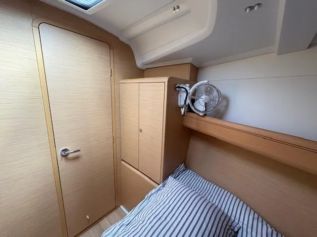 Slide: The Image of Cozy cabin interior of 2018 Jeanneau Sun Odyssey 389 sailboat with striped bedding. - 19