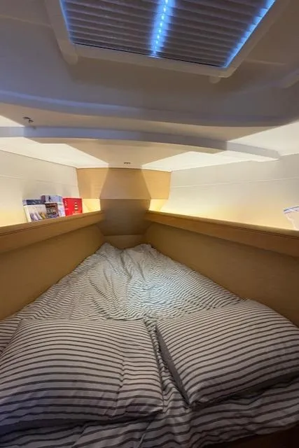Slide: The Image of Cozy cabin interior of 2018 Jeanneau Sun Odyssey 389 sailboat with striped bedding. - 20