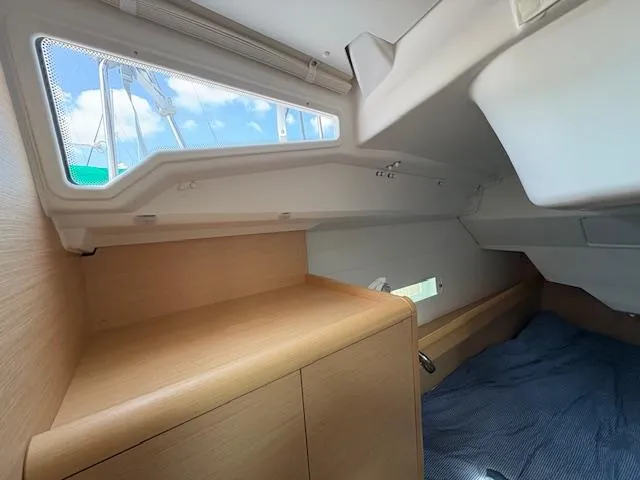 Slide: The Image of 2018 Jeanneau Sun Odyssey 389 cabin interior with wooden finish and blue bedding. - 21