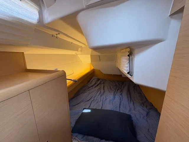 Slide: The Image of Cozy cabin interior of 2018 Jeanneau Sun Odyssey 389 sailboat, featuring a comfortable bed and storage. - 22