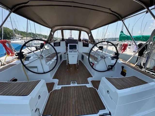 Slide: The Image of 2018 Jeanneau Sun Odyssey 389 cockpit with dual steering wheels and teak flooring. - 6