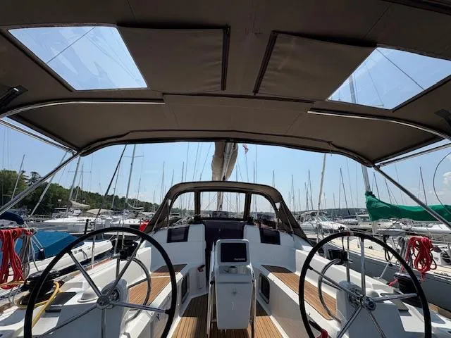 Slide: The Image of 2018 Jeanneau Sun Odyssey 389 sailboat cockpit with dual steering wheels in marina. - 8