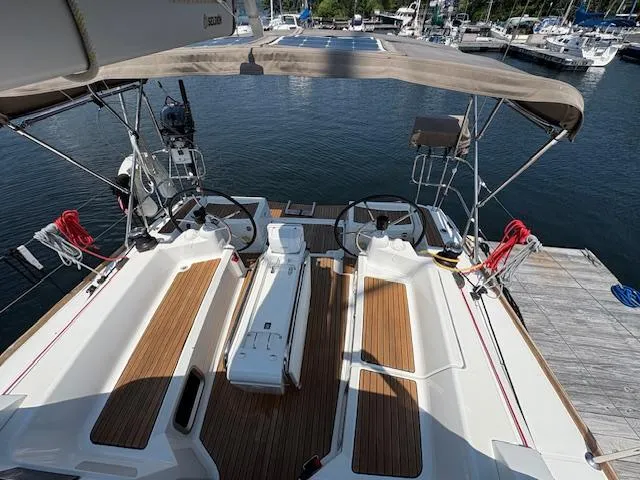 Slide: The Image of 2018 Jeanneau Sun Odyssey 389 sailboat cockpit with dual steering wheels and teak flooring. - 9