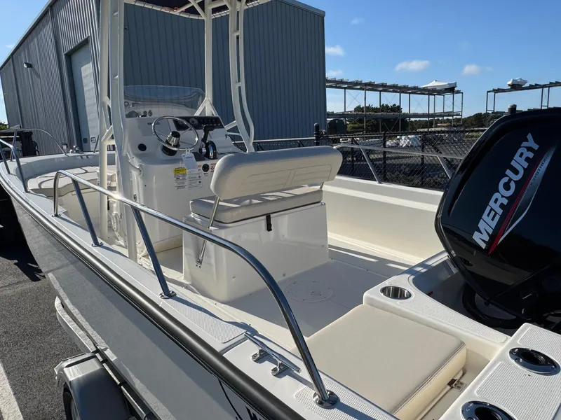 Slide: The Image of 2025 Boston Whaler 190 Montauk boat with Mercury engine, docked outdoors. - 6