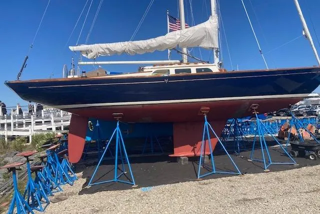 Slide: The Image of Sailboat on stands, Morris M36, 2005 model, with American flag, blue hull, white deck. - 0