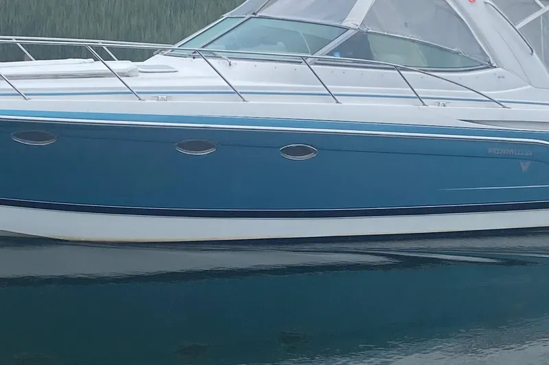 Slide: The Image of 2012 Formula 31PC boat with blue hull and sleek design on calm water. - 2