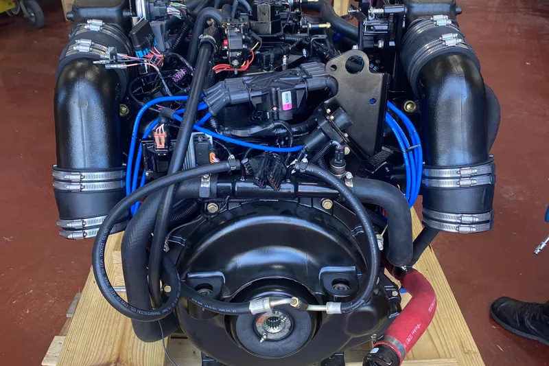 Slide: The Image of 2012 Formula 31PC engine with black hoses and blue wiring on a wooden platform. - 24