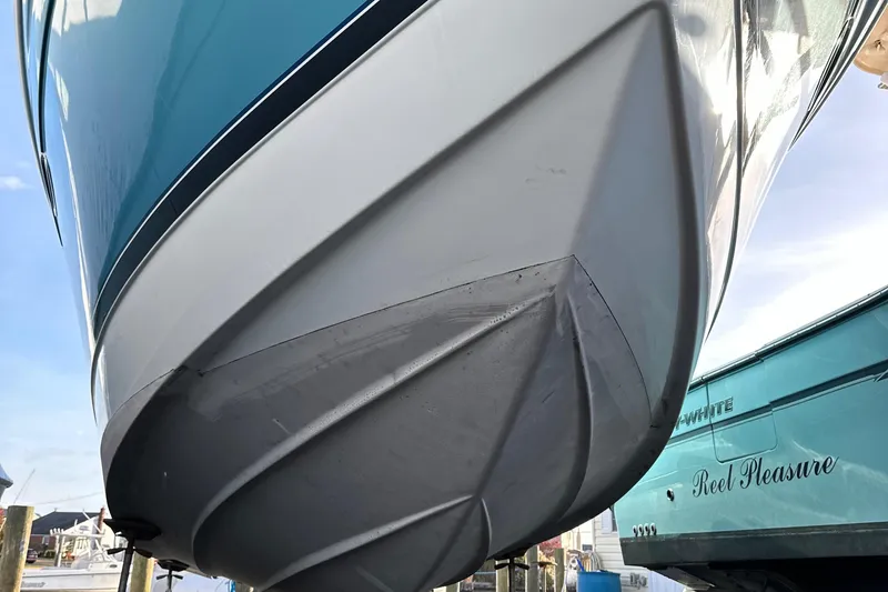 Slide: The Image of 2005 Formula 31PC boat hull, docked, showcasing sleek design and vibrant blue color. - 29