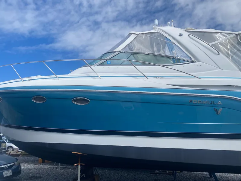 Slide: The Image of 2012 Formula 31PC boat with blue hull, docked under a clear sky. - 3