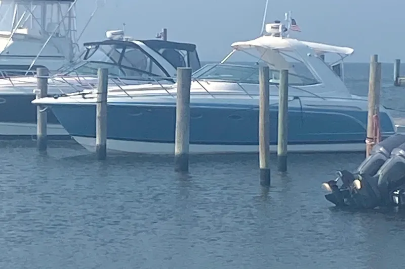 Slide: The Image of 2012 Formula 31PC boat docked in marina, blue and white exterior, calm water. - 4