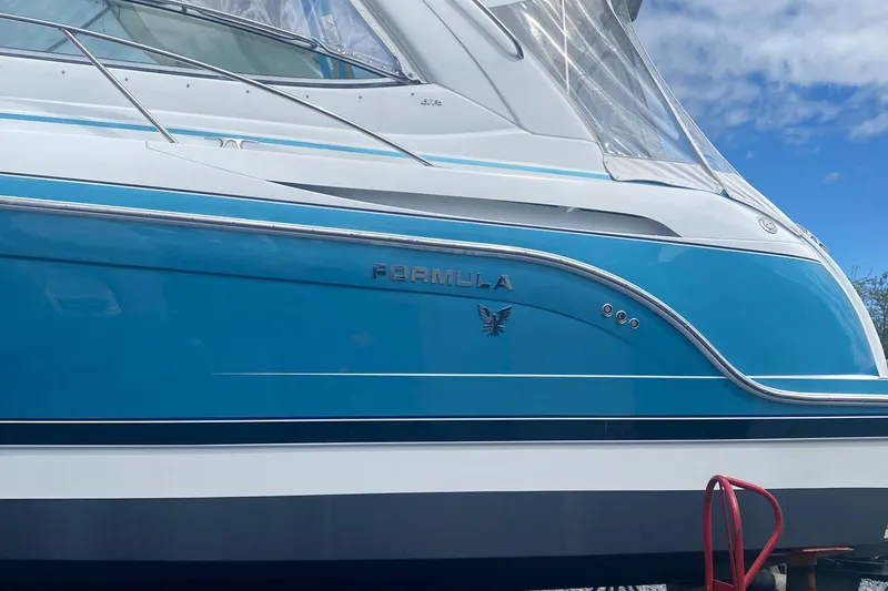 Slide: The Image of 2012 Formula 31PC boat with blue and white exterior, docked under a clear sky. - 8