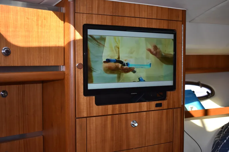Slide: The Image of 2008 Tiara Sport Fish interior with mounted TV and wooden cabinetry. - 24