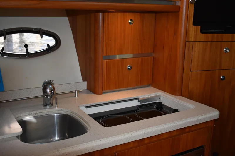 Slide: The Image of 2008 Tiara Sport Fish yacht kitchen with sink, stove, and wooden cabinetry. - 25