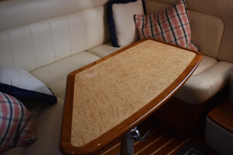 Slide: The Image of 2008 Tiara Sport Fish interior with cushioned seating and wooden table. - 26