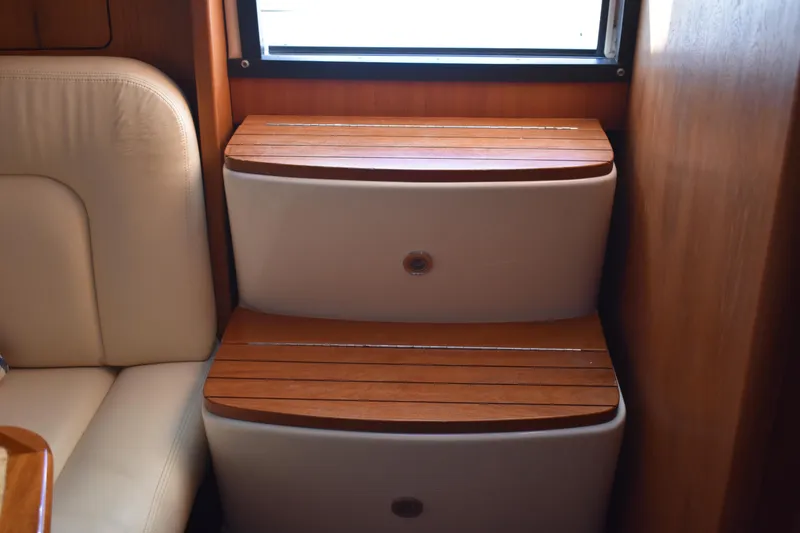 Slide: The Image of Wooden steps inside 2008 Tiara Sport Fish boat cabin, next to a cushioned seat. - 27
