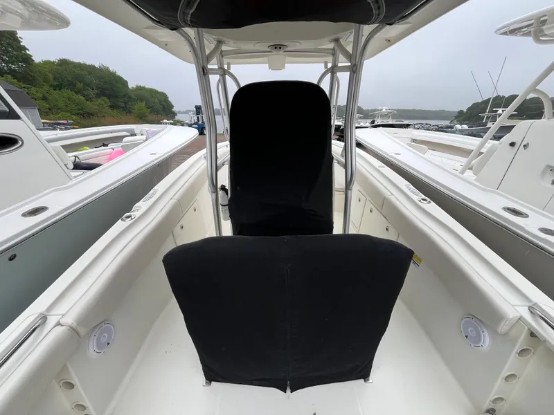 Slide: The Image of 2007 Hydra-Sports 2500CC boat interior with black seat covers, docked near lush greenery. - 17