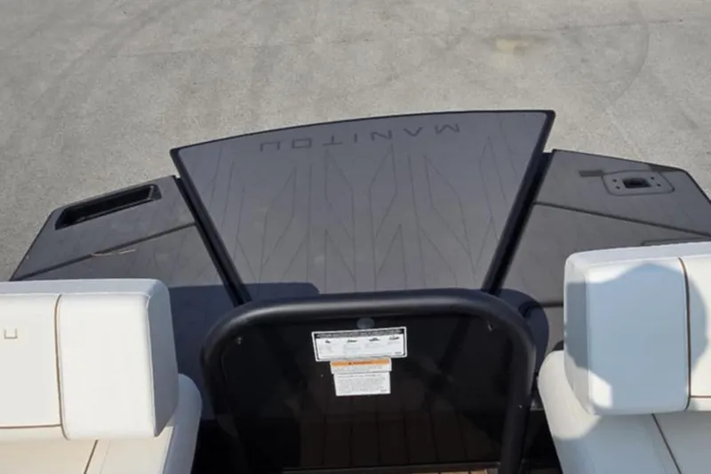 Slide: The Image of 2025 Manitou Explore boat interior with white seating and sleek design. - 13