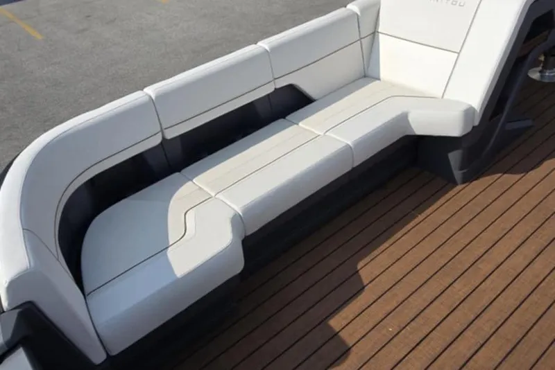 Slide: The Image of Luxurious seating on 2025 Manitou Explore boat with sleek white upholstery and wooden deck. - 15