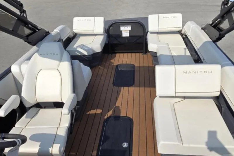 Slide: The Image of 2025 Manitou Explore boat interior with white seating and wooden flooring. - 9