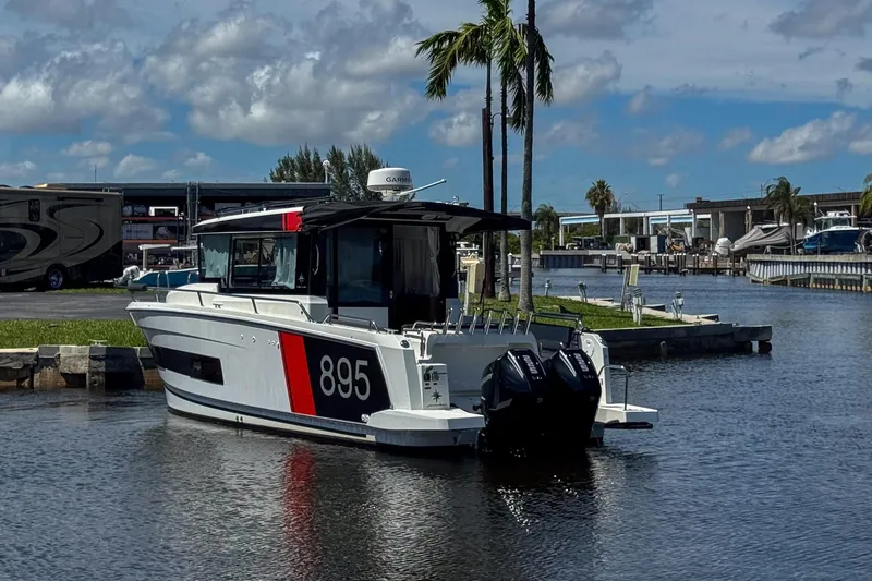 Slide: The Image of 2018 Jeanneau NC 895 boat docked in a marina under a blue sky. - 11