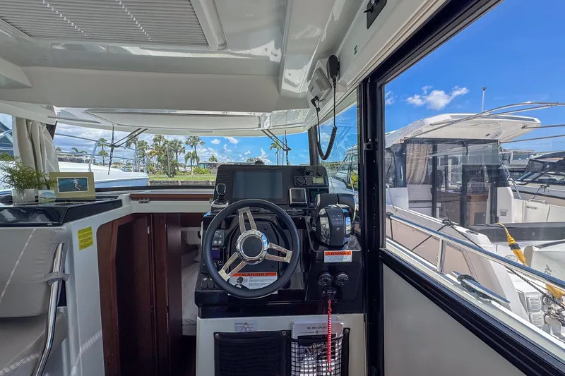 Slide: The Image of Interior view of 2018 Jeanneau NC 895 boat cockpit with steering wheel and navigation equipment. - 17