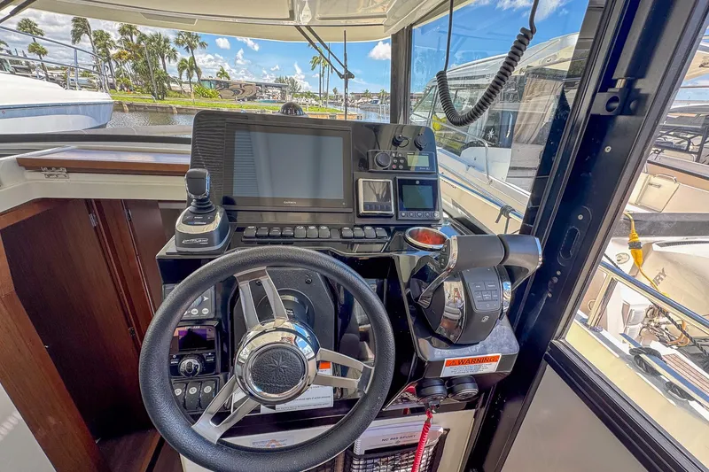 Slide: The Image of 2018 Jeanneau NC 895 helm with steering wheel, navigation controls, and display screens. - 19