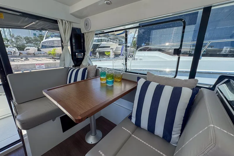 Slide: The Image of Interior of 2018 Jeanneau NC 895 boat with dining area and striped cushions. - 20