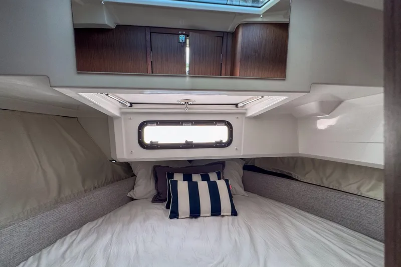 Slide: The Image of Cozy cabin interior of 2018 Jeanneau NC 895 with striped pillows and window. - 22