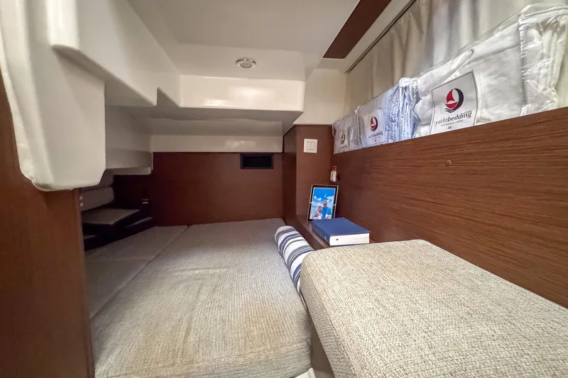 Slide: The Image of 2018 Jeanneau NC 895 cabin interior with cozy bedding and wooden accents. - 26