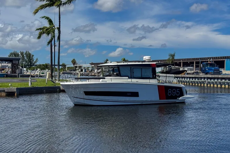 Slide: The Image of 2018 Jeanneau NC 895 boat docked in a marina under a clear blue sky. - 3