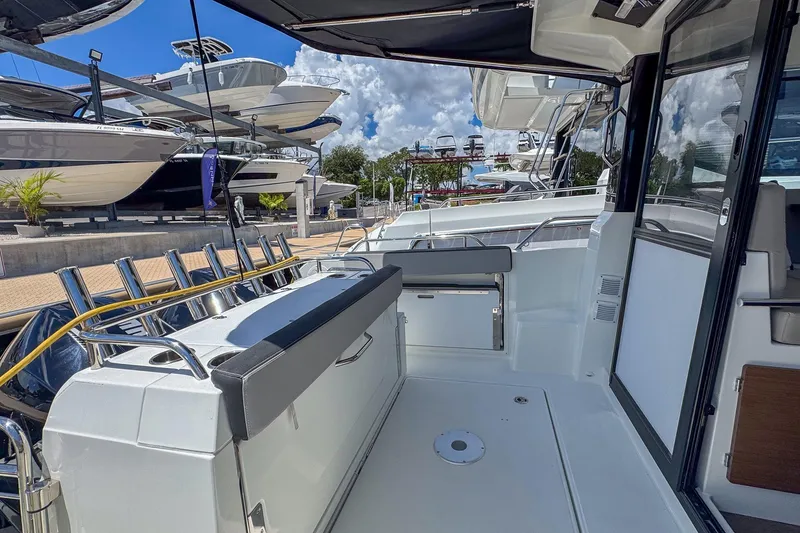 Slide: The Image of 2018 Jeanneau NC 895 boat interior with seating, docked under a blue sky. - 31