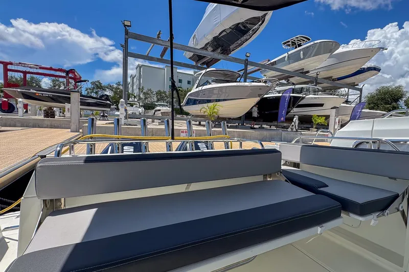 Slide: The Image of 2018 Jeanneau NC 895 boat in marina, surrounded by other docked vessels under a clear blue sky. - 32