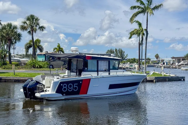 Slide: The Image of 2018 Jeanneau NC 895 boat docked near palm trees and marina. - 7