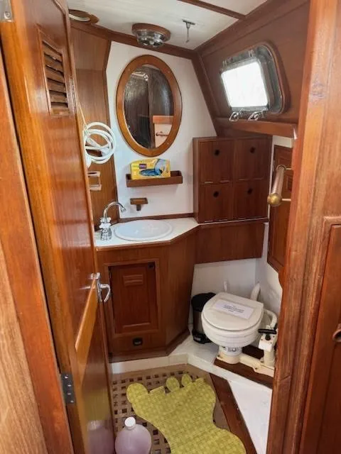 Slide: The Image of 1978 Cheoy Lee Off Shore 41 yacht bathroom with wooden cabinetry and nautical decor. - 11