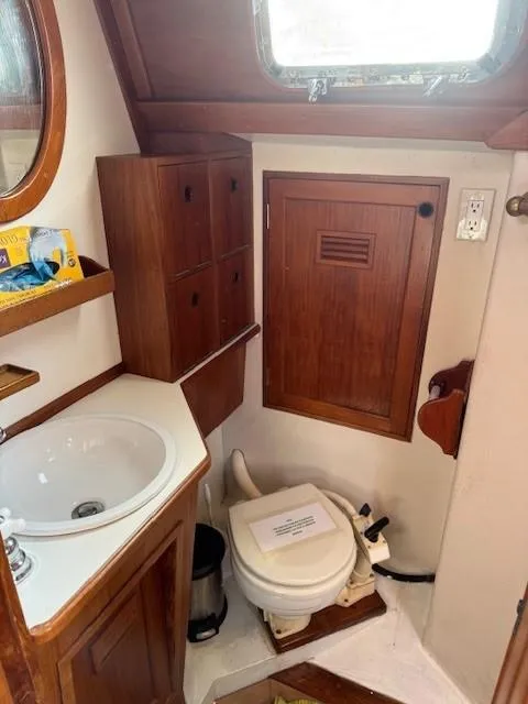 Slide: The Image of 1978 Cheoy Lee Off Shore 41 yacht bathroom with wooden cabinetry and compact sink. - 12