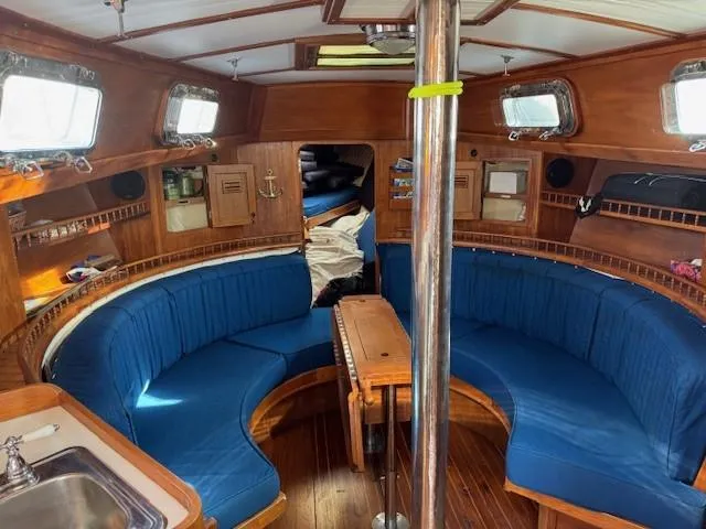 Slide: The Image of 1978 Cheoy Lee Off Shore 41 yacht interior with blue seating and wooden finishes. - 7