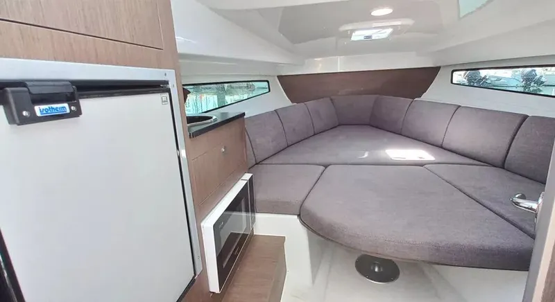 Slide: The Image of Interior of 2026 Beneteau FLYER 8 SUNDECK V2, featuring cozy seating and compact kitchenette. - 3