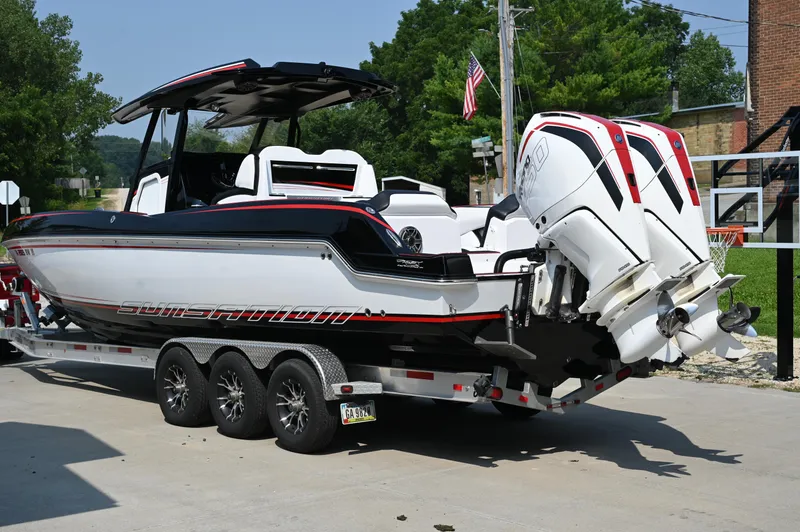 Slide: The Image of 2023 Sunsation 32 CCX boat on trailer with dual outboard engines, parked outdoors. - 10