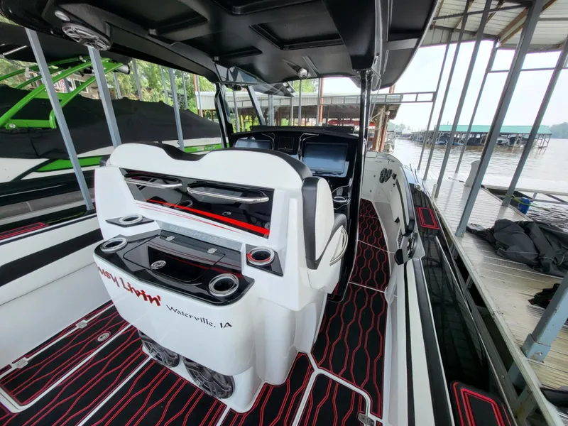 Slide: The Image of 2023 Sunsation 32 CCX boat interior with modern design and advanced controls at a dock. - 18