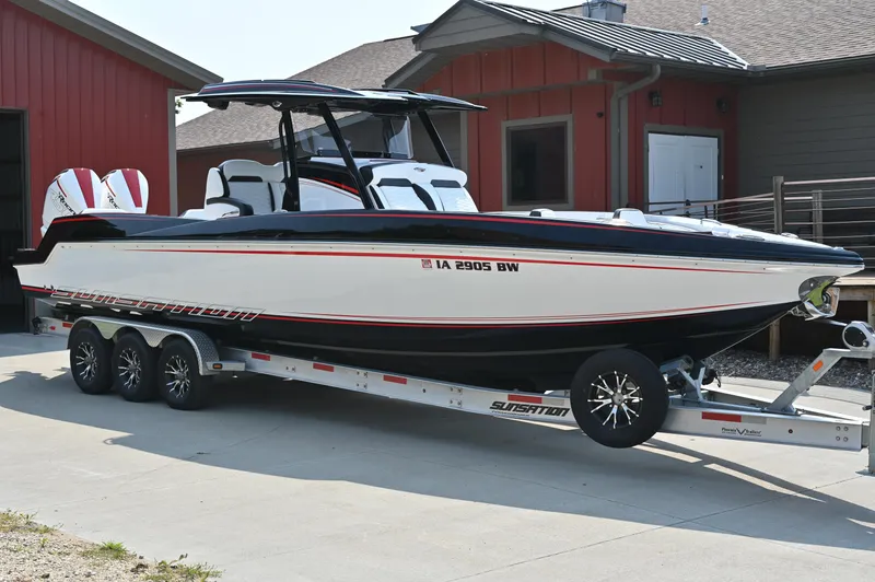 Slide: The Image of 2023 Sunsation 32 CCX boat on trailer, parked outside red building. - 3