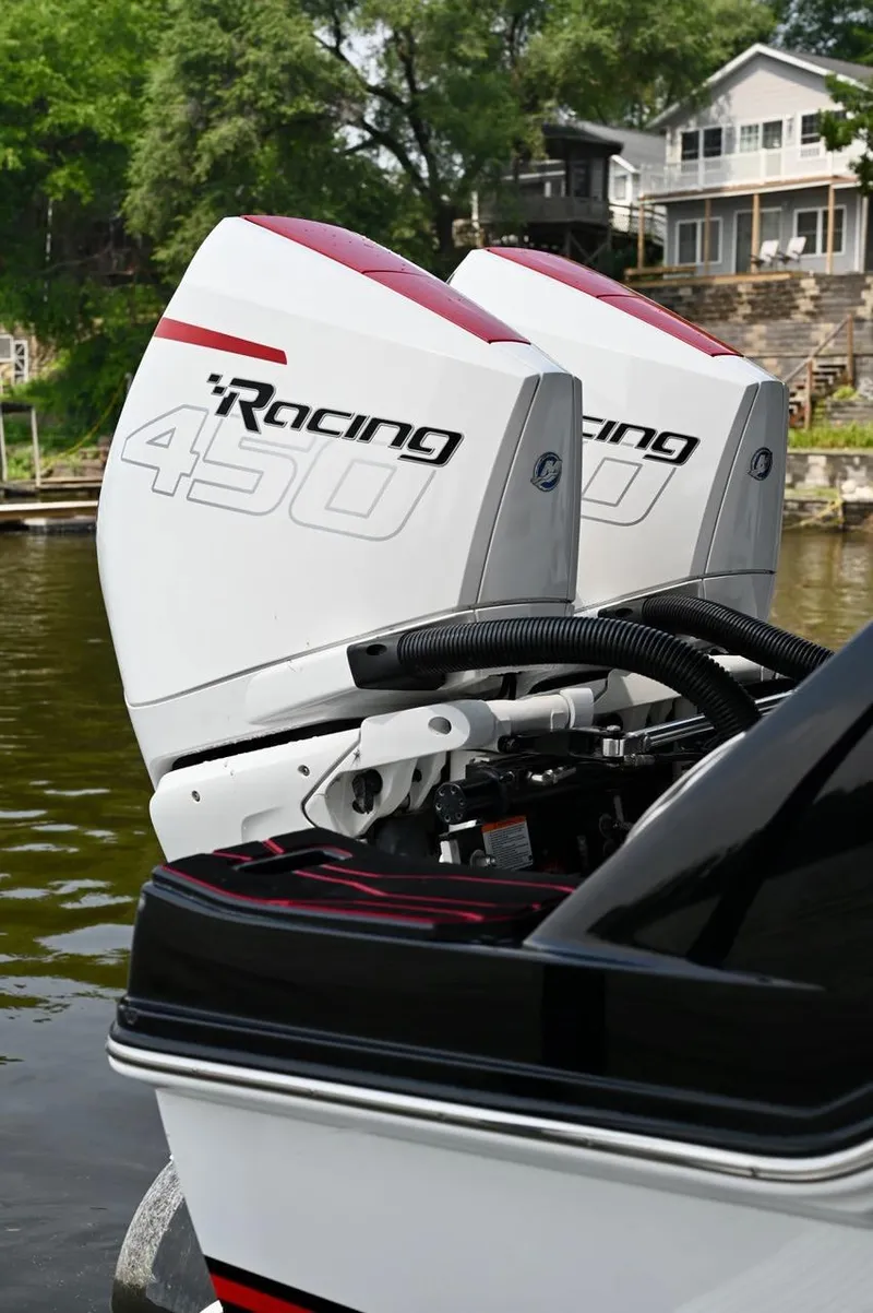 Slide: The Image of Twin Racing 450 engines on a 2023 Sunsation 32 CCX boat by the water. - 5