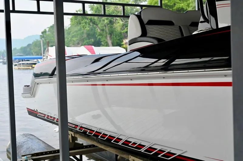 Slide: The Image of 2023 Sunsation 32 CCX boat docked, featuring sleek design and red accents. - 6