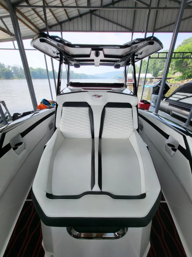 Slide: The Image of 2023 Sunsation 32 CCX boat interior with sleek white seating under a covered dock. - 9