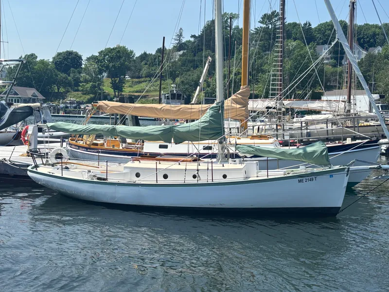 The Image of 1951 Custom Pilot Cutter sailboat docked in a scenic marina. - 0