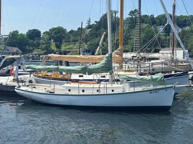 Slide: The Image of Vintage 1951 Custom Pilot Cutter docked in a scenic marina setting. - 1