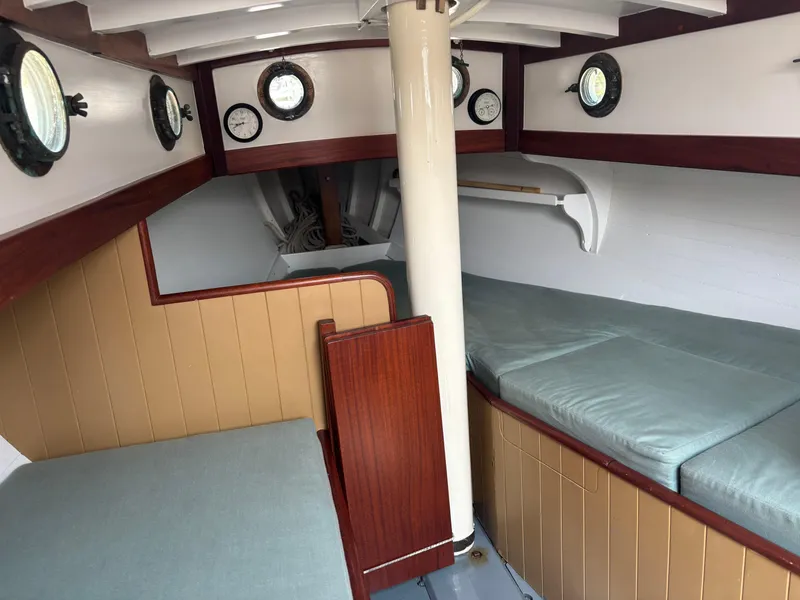 Slide: The Image of Interior of a 1951 Custom Pilot Cutter with wooden paneling and cushioned seating. - 10